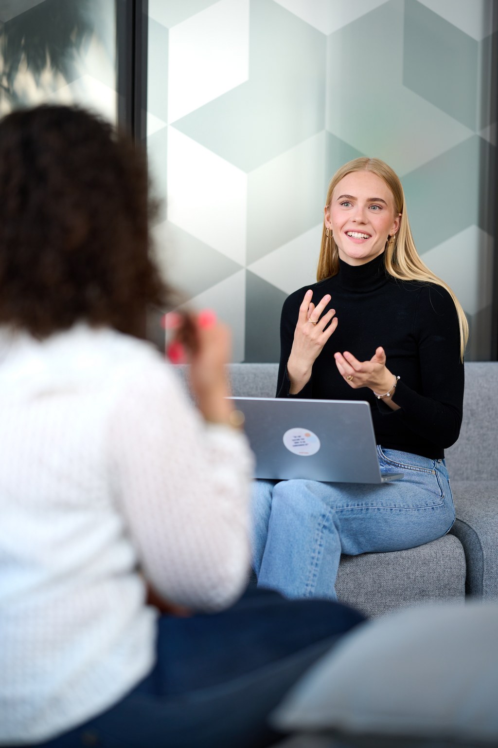 Two women discussing over computers