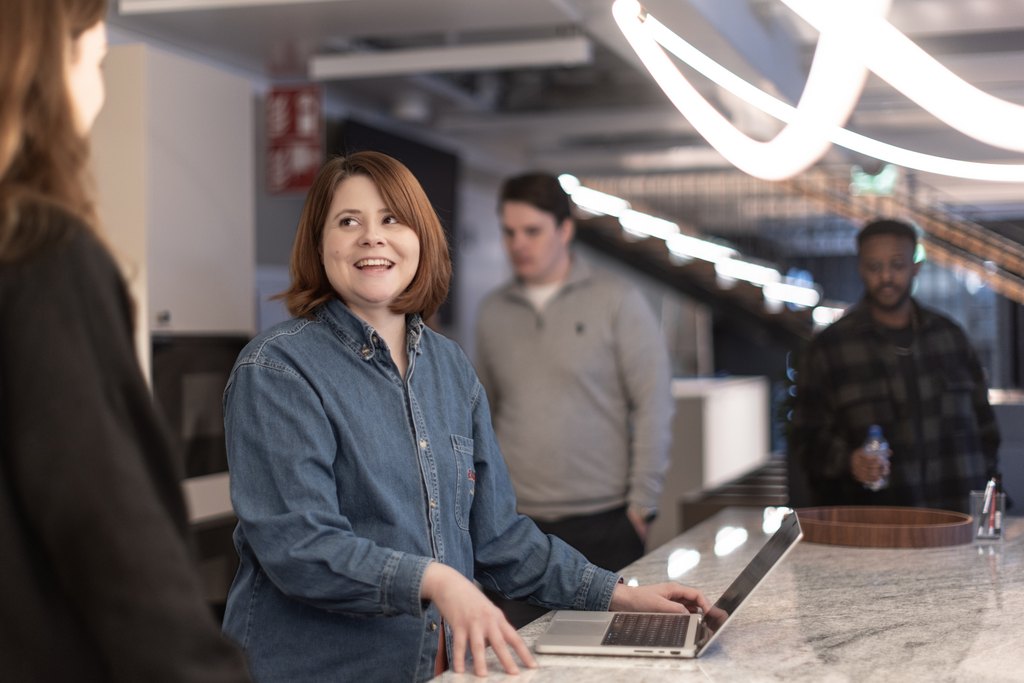 a woman with a laptop looking at another person