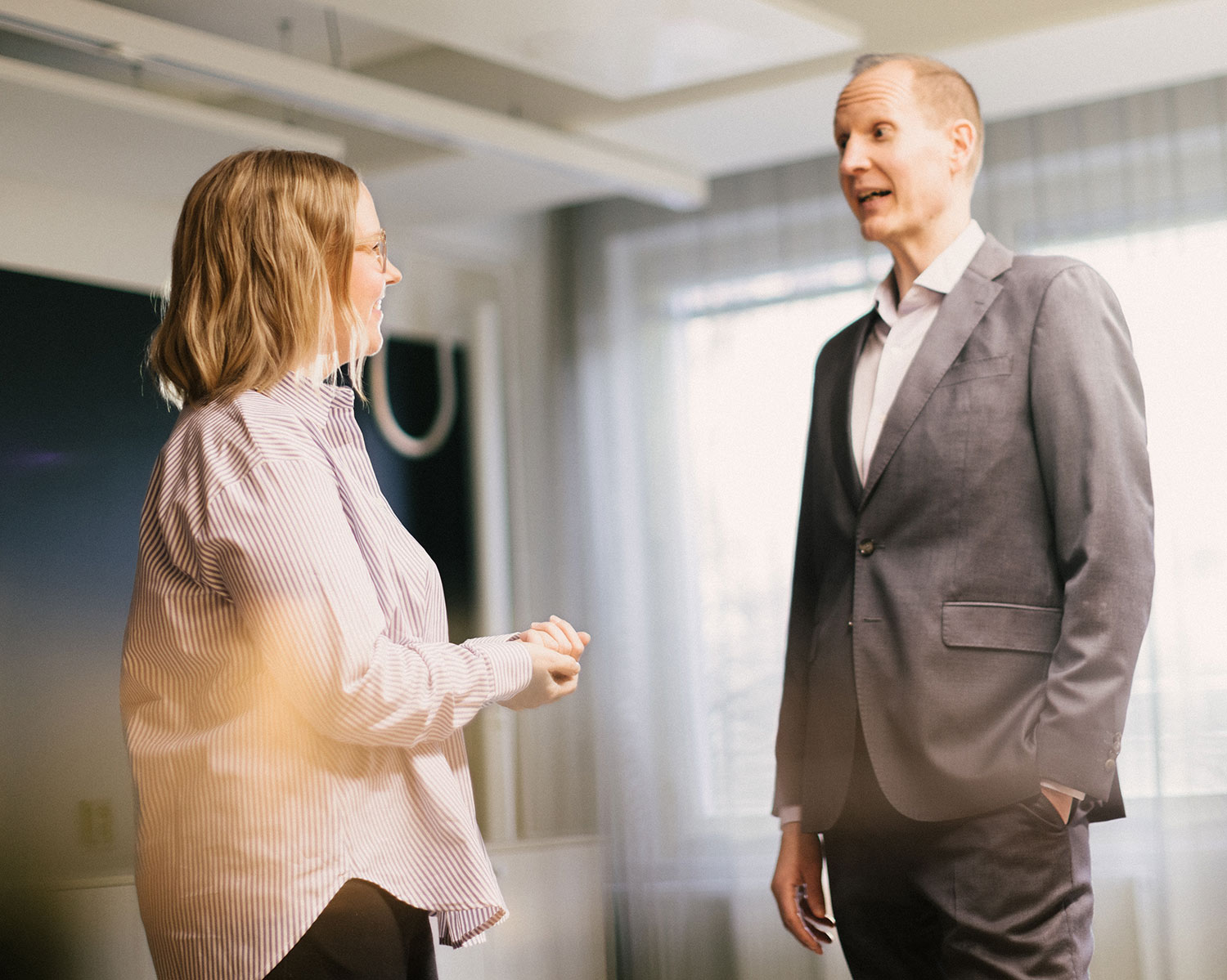 Man and woman stand facing each other, discussing