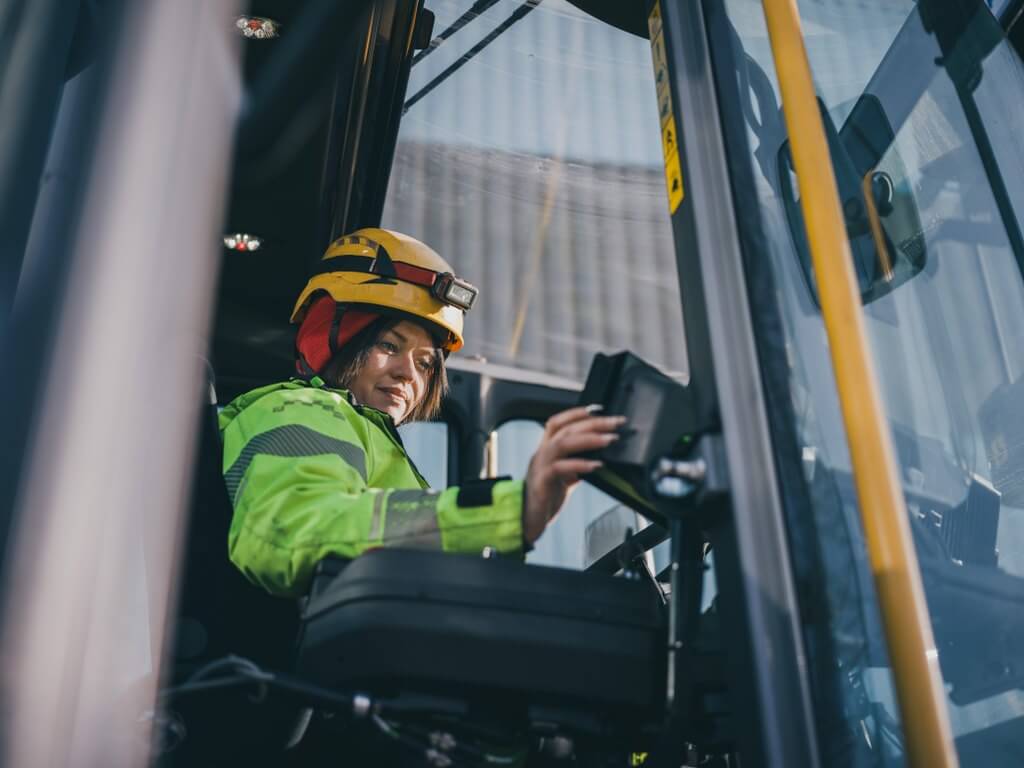 Woman operating a forklift in a factory environment
